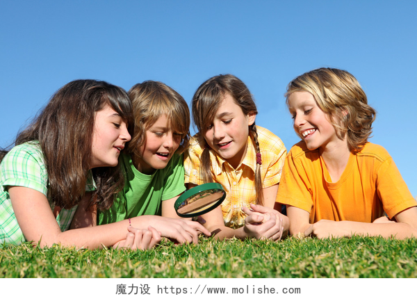 一群孩子拿着放大镜在草地上玩耍孩子们在夏令营玩放大镜